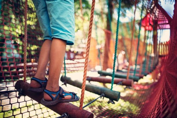 Child walking in modern ropes course playground Child playing in modern playground.  Sunny summer day.
 safety net stock pictures, royalty-free photos & images