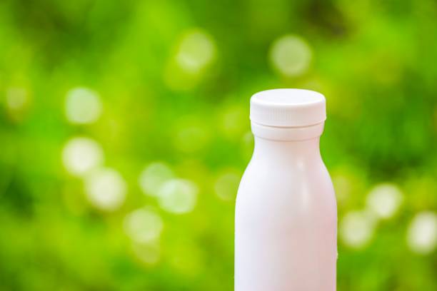 istock bottle plastic white on the wood and tree blurry bokeh background in garden. Using wallpaper for package  with product image. 827540446