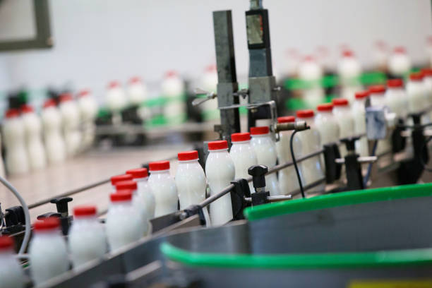 bottiglie di latte in una fabbrica di latte - yogurt container foto e immagini stock