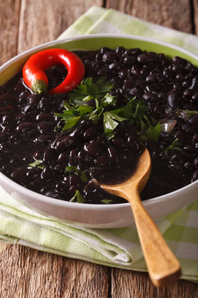 istock Stewed spicy black beans close up in a bowl. vertical 827544312