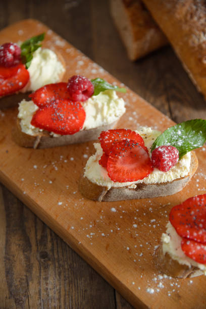 istock Fruit brusquest with raspberry and cottage cheese on a wooden board 827546508
