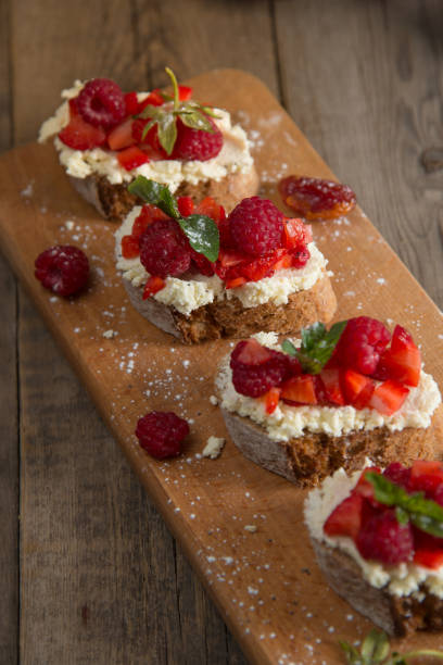 istock Fruit brusquest with raspberry and cottage cheese on a wooden board 827549456
