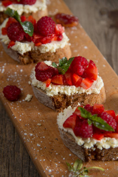 istock Fruit brusquest with raspberry and cottage cheese on a wooden board 827549548