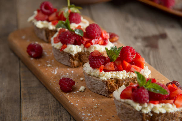 istock Fruit brusquest with raspberry and cottage cheese on a wooden board 827549632
