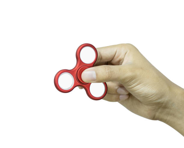 istock Hand holding fidget spinner isolated on white background. Stress relieving toy. 827549786