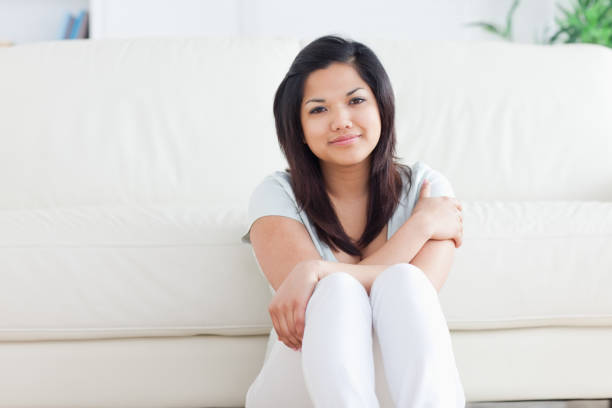 istock Smiling woman sitting on the floor 827550238