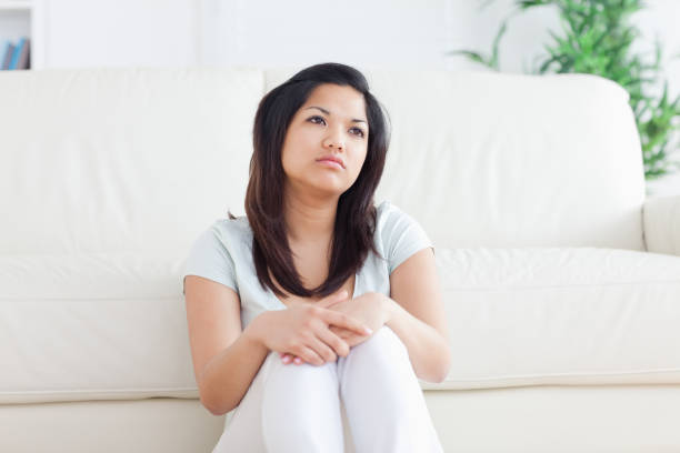 istock Woman is sitting in front of a couch 827550542