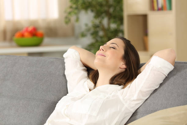 istock Woman relaxing alone on a couch at home 827555464