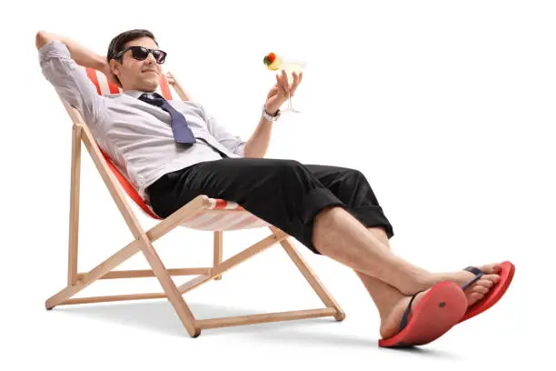 Photo of Businessman with a cocktail relaxing in a deck chair