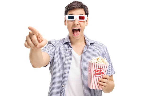 istock Joyful guy with a pair of 3D glasses and popcorn laughing 827556028
