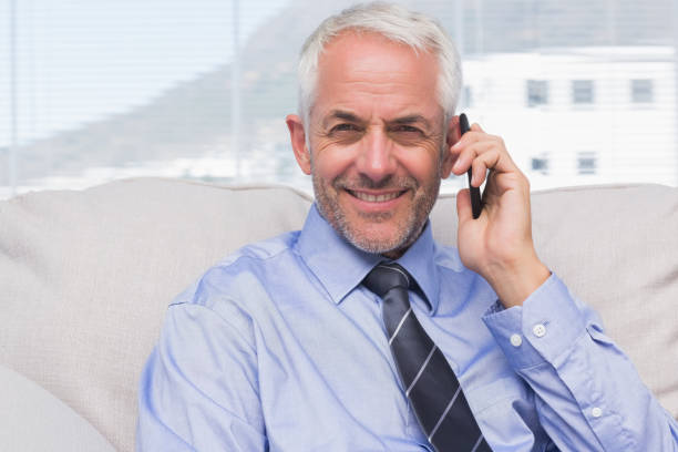 istock Businessman calling on smartphone and smiling at camera 827559630