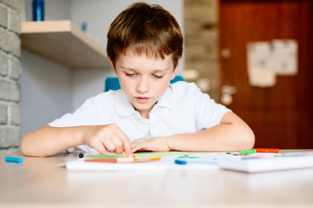 istock Seven years old boy drawing a picture 827562780