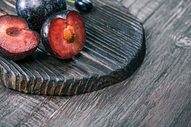 Red plum on wooden board