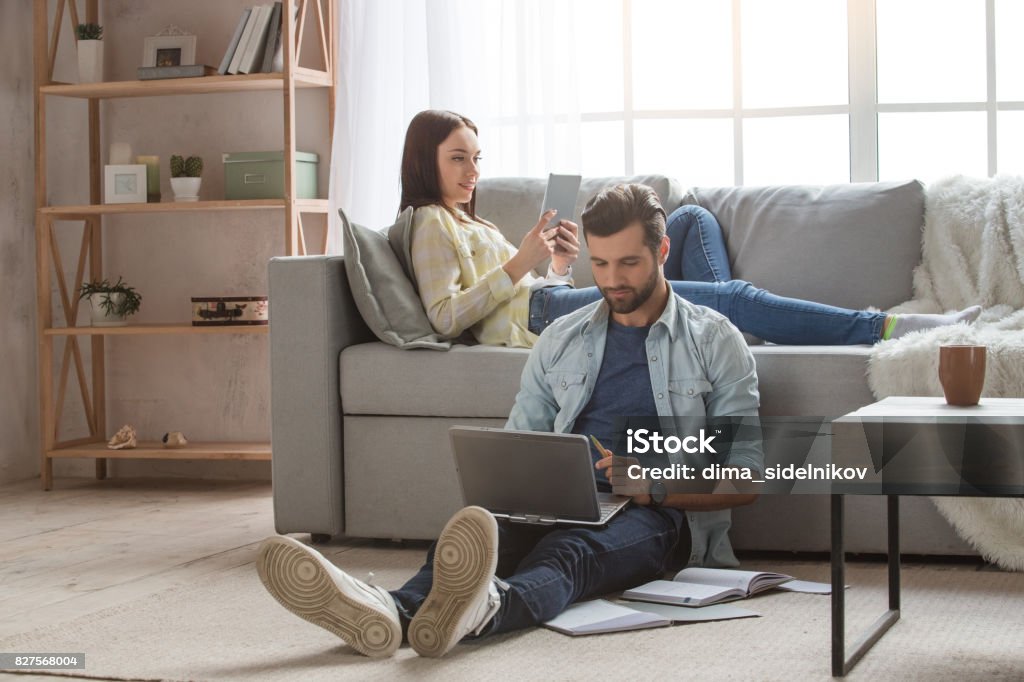 Young family couple together at home casual Young woman and man family couple indoors using laptop Family Stock Photo