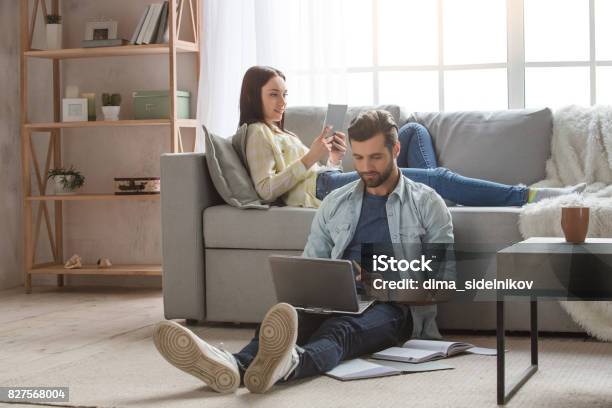 Young Family Couple Together At Home Casual Stock Photo - Download Image Now - Family, Domestic Life, Living Room