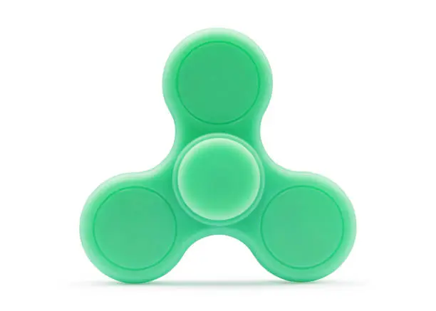 Photo of Green fidget spinner isolated on white background. Stress relieving toy