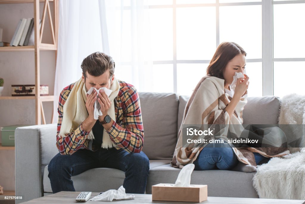 Jeune couple famille ensemble à domicile occasionnel - Photo de État grippal libre de droits