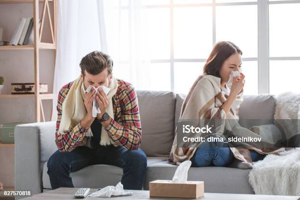 Young Family Couple Together At Home Casual Stock Photo - Download Image Now - Cold And Flu, Illness, Family