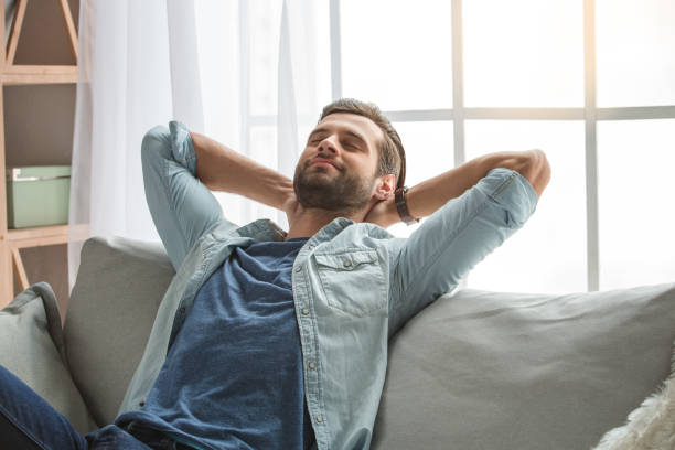 istock Young man sitting on coach rest at home 827571576