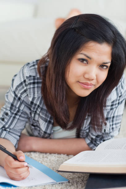 istock Woman laying on the floor while writing on a notebook 827576022