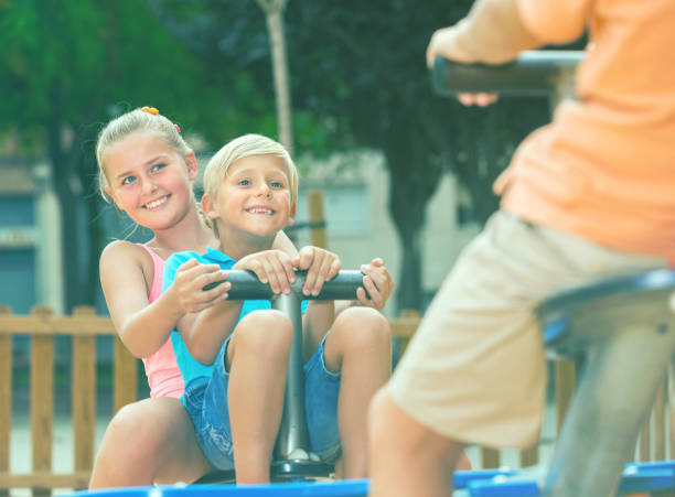 istock Cheerful children are teetering on the swing 827576520