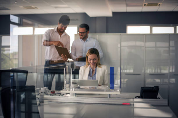 istock Three business people working in office. Two business people having reading document. 827579696