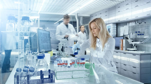 istock Team of Research Scientists Working With Personal Computer, Analysing Test Trial New Generation Drug Data. They Work in a Modern Laboratory/ Medical Center. 827579990