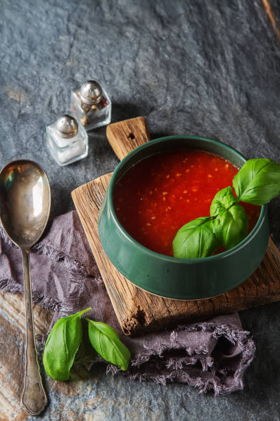 Traditional Italian tomato soup gazpacho with basil. Dark backgr