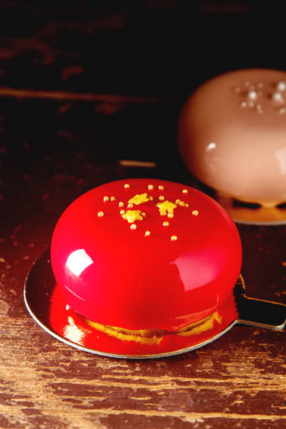 Festive dessert, red velvet cake on table in cafe, in sunlight. Single round cake topped with sponge cake soaked in red syrup. Celebration concept, sweets, cheat meal, little joys, weaknesses.