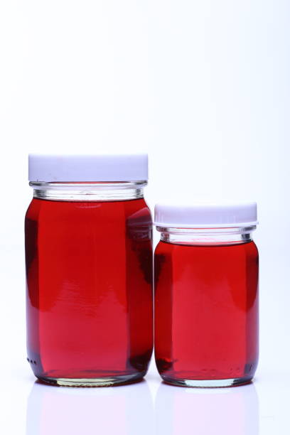 istock Red Liquid in Glass Bottle white cap 827583668