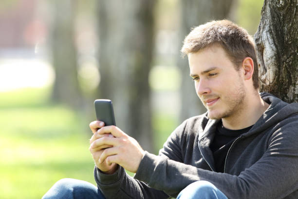istock Boy reading messages in a smart phone outdoors 827587928