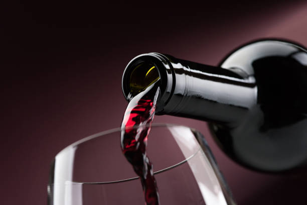 pouring red wine into a wineglass - wineglass red wine wine liquid imagens e fotografias de stock