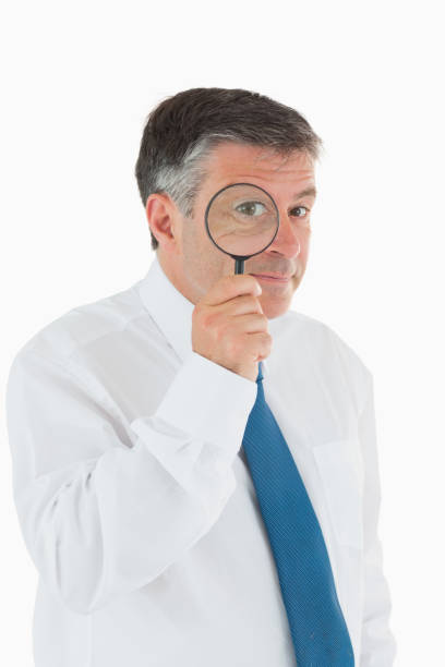 istock Inquisitive businessman with magnifying glass 827607880