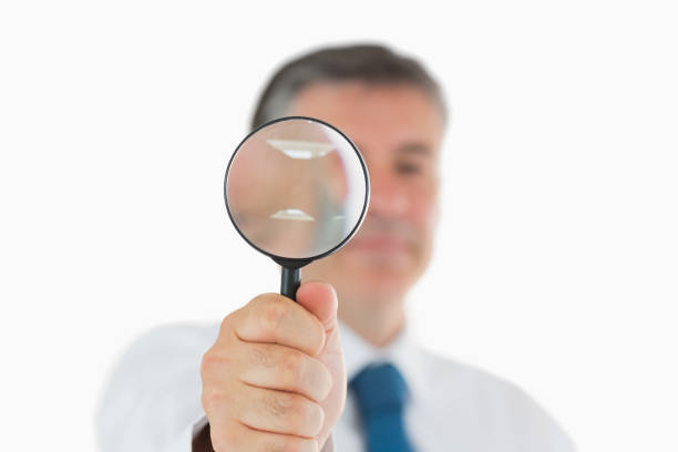 istock Businessman holding up magnifying glass 827607904