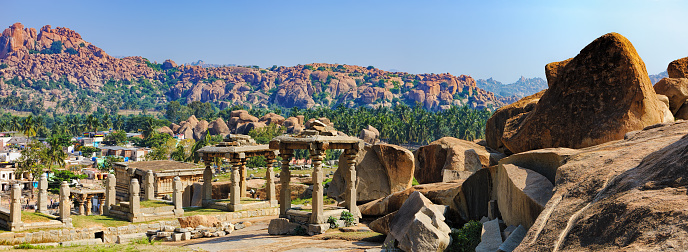Virupaksha Temple, located in the ruins of ancient city Vijayanagar at Hampi, India. Landscape with unique mountain formation, tropical nature on the horizon and old hindu temple.