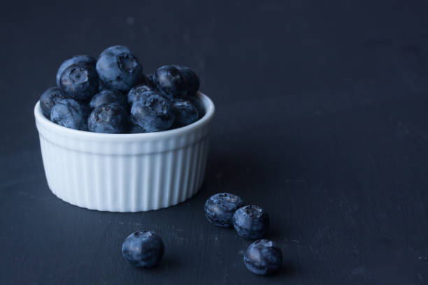 istock Blueberries in a bowl on a black background 827614936