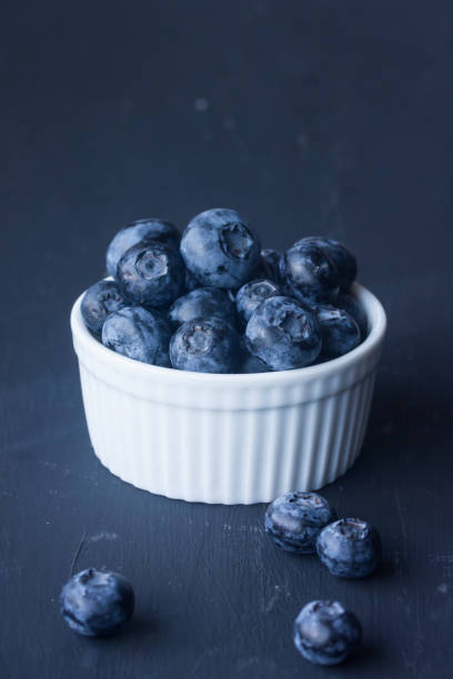 istock Blueberries in a bowl on a black background 827614952