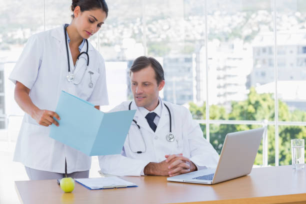 istock Doctor showing a folder to a colleague 827624002