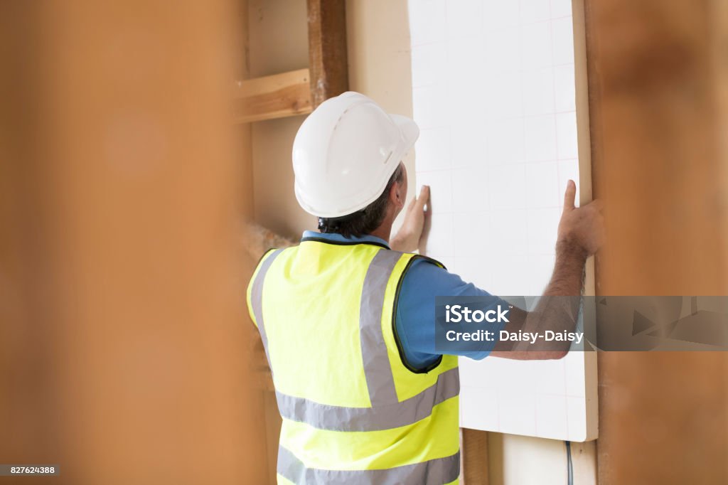 Builder Fitting Insulation Boards Into Roof Of New Home Insulation Stock Photo