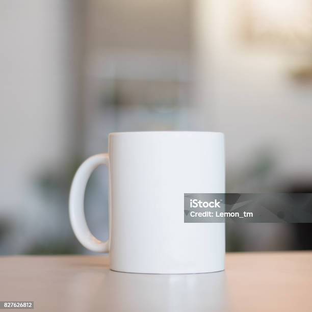 Blanco Taza Sobre La Mesa Y El Fondo De La Habitación Moderna Taza De La Bebida En Blanco Para Su Diseño Puede Poner Texto Imagen Y Logotipo Foto de stock y más banco de imágenes de Taza sin platillo