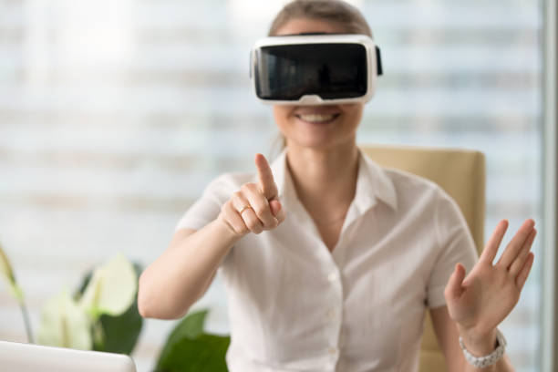 istock Smiling woman in headset enjoying VR tour, touching virtual world 827627406