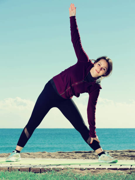 istock Glad girl exercising on exercise mat 827628524