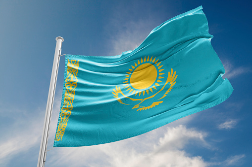 Kazakhstan flag is waving at a beautiful and peaceful sky in day time while sun is shining. 3D Rendering