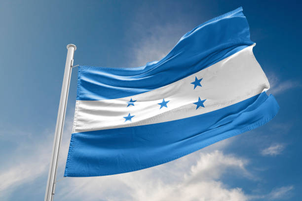 honduras flagge ist winken gegen blauen himmel - honduras stock-fotos und bilder