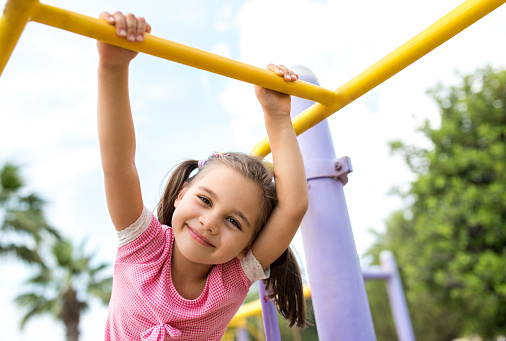 Little Girl Playing At Playground Outdoors In Summer