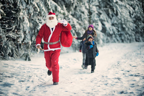 Santa Claus spotted in the forest by a group of children. Santa is running away from the children that are chasing after him.\n