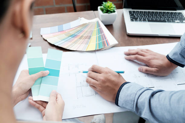 istock Graphic design and color swatches and pens on a desk. Architectural drawing with work tools and accessories. 827639148