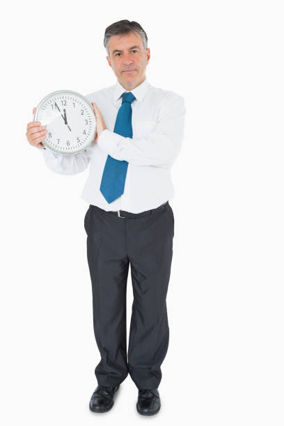 istock Serious businessman holding clock 827642442