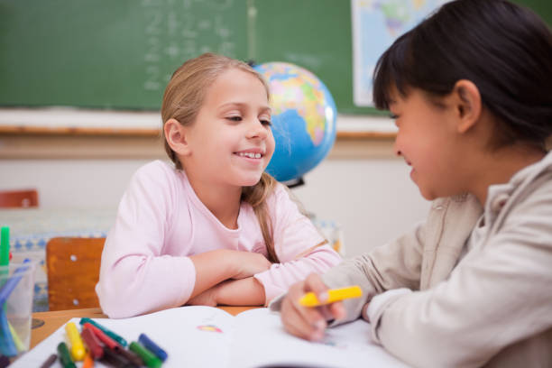 istock Happy schoolgirls drawing 827642576