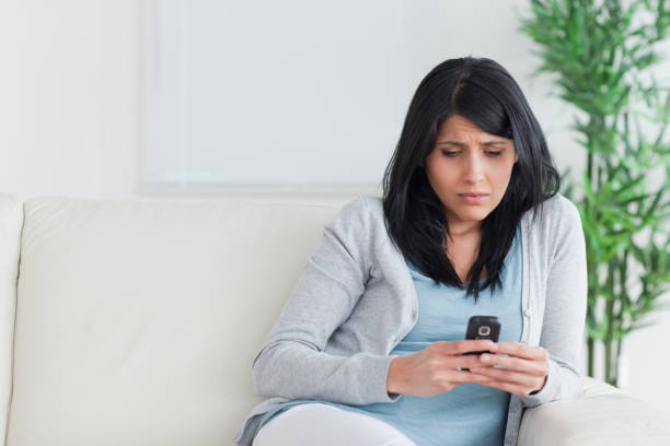 istock Woman looking at a phone on a couch 827646832